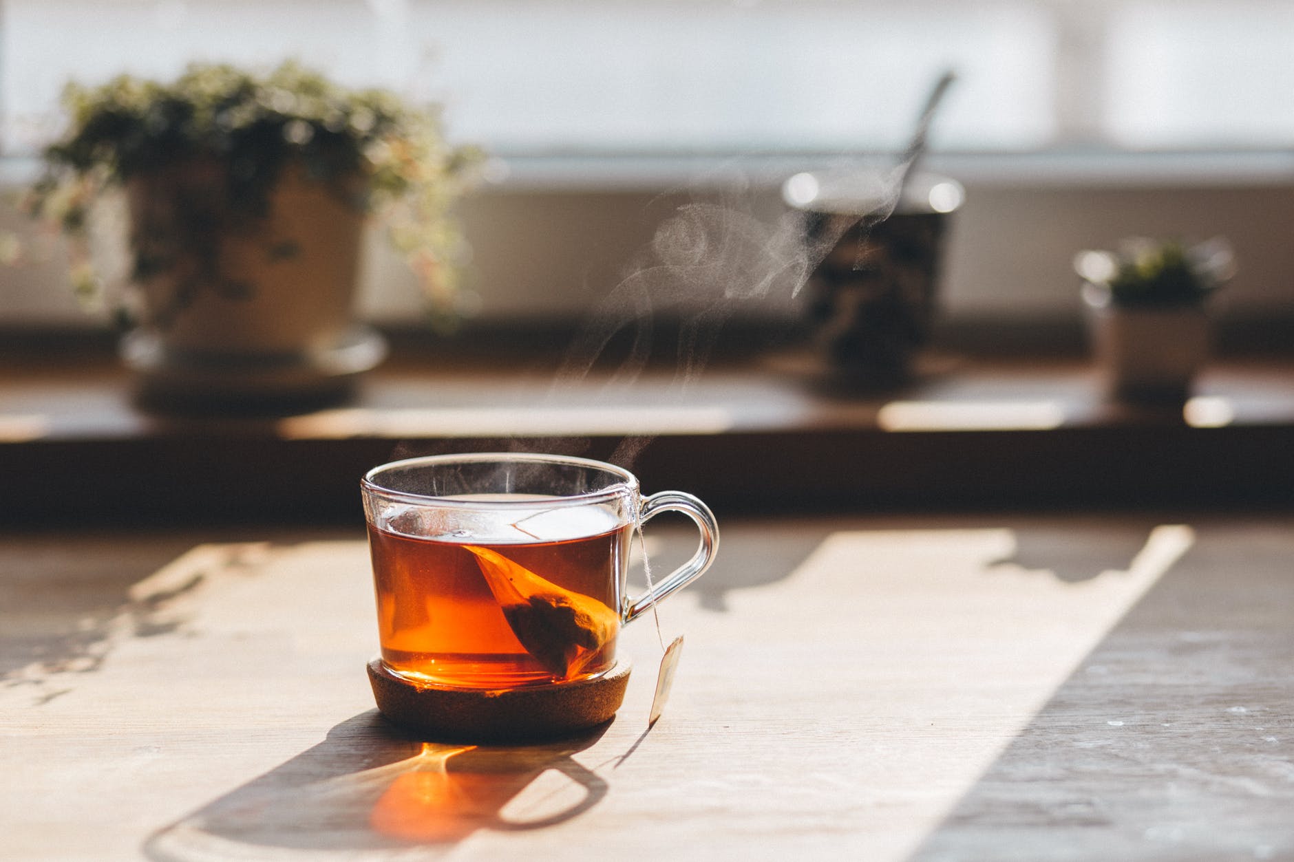 Clear glass of tea with tea bag in wondow