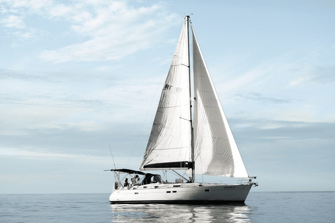 A white sailboat floating on calm water under a clear sky with a few clouds. How to Protect Your Luxury Assets from Life’s Little Surprises