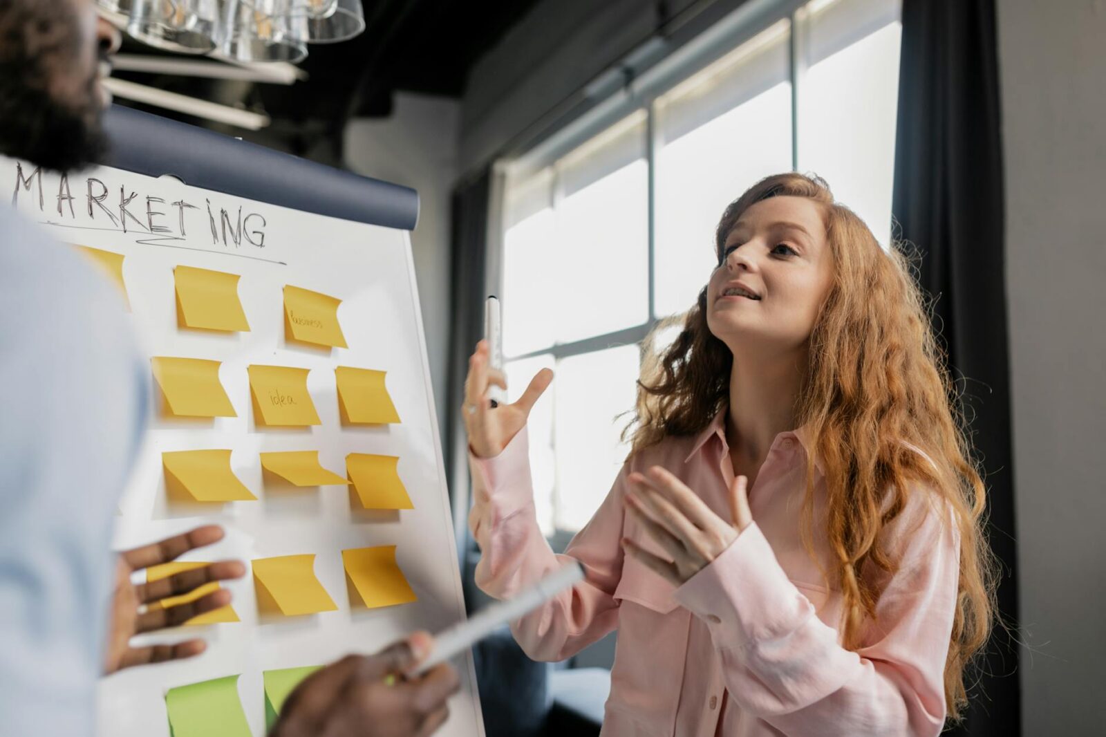 Are You Struggling With Your Business? How to Fix It and Grow Stronger 12 a woman talking about marketing near a board with post its Are You Struggling With Your Business? How to Fix It and Grow Stronger